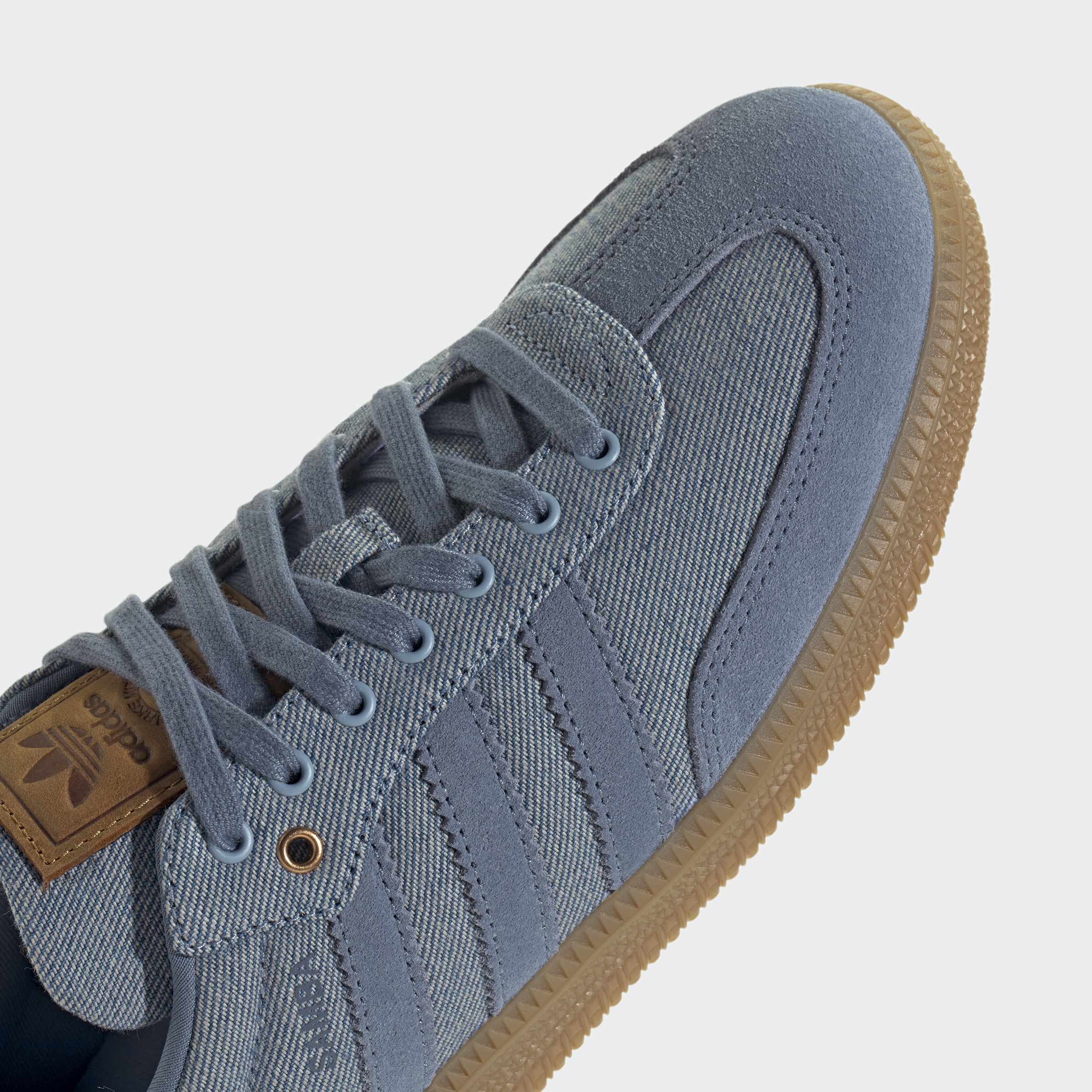 נעלי סניקרס אופנתיות בגוון כחול עם סוליית גומי חומה, תפרים בולטים ועיצוב מודרני