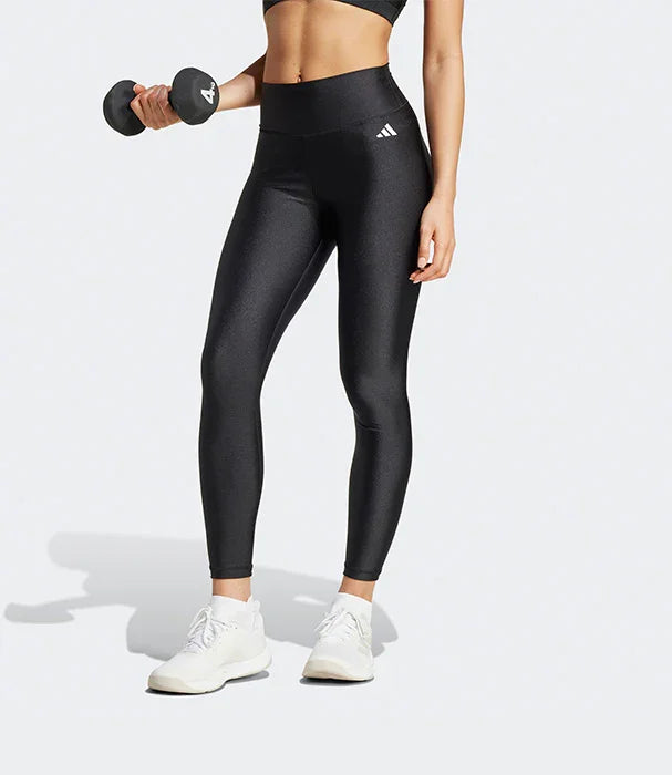 אישה בבגדי ספורט שחורים של אדידס, מחזיקה משקולת, צילום סטודיו ל-CHOZEN