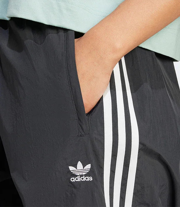 מכנסי אדידס שחורים עם שלושה פסים לבנים ולוגו adidas, צילום תקריב CHOZEN