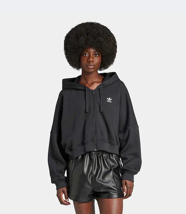 אישה לובשת קפוצ'ון שחור של אדידס ומכנסי עור, אופנה מבית CHOZEN