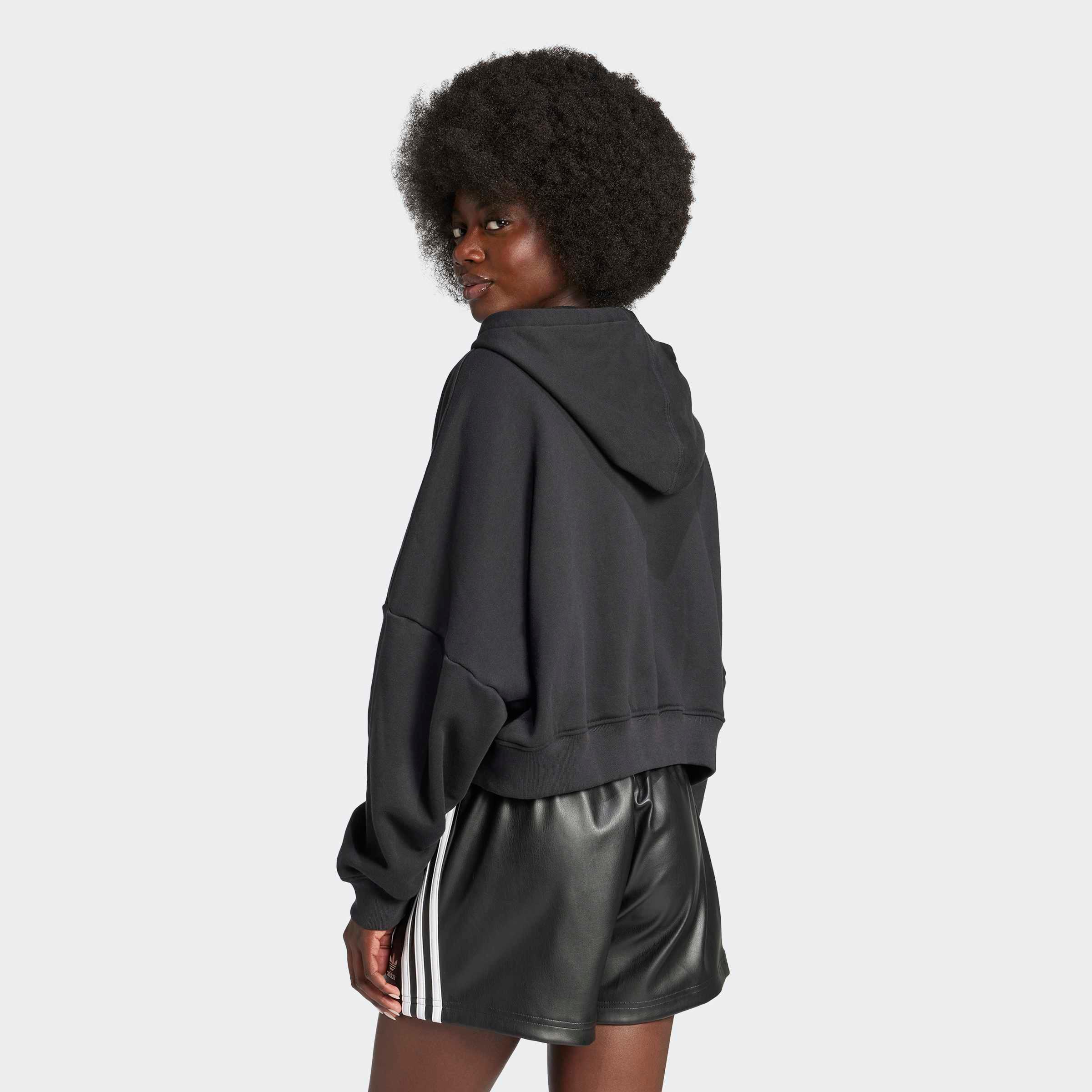 אישה עם קפוצ'ון שחור ומכנסי עור קצרים עם פסים לבנים, אופנת ספורט CHOZEN