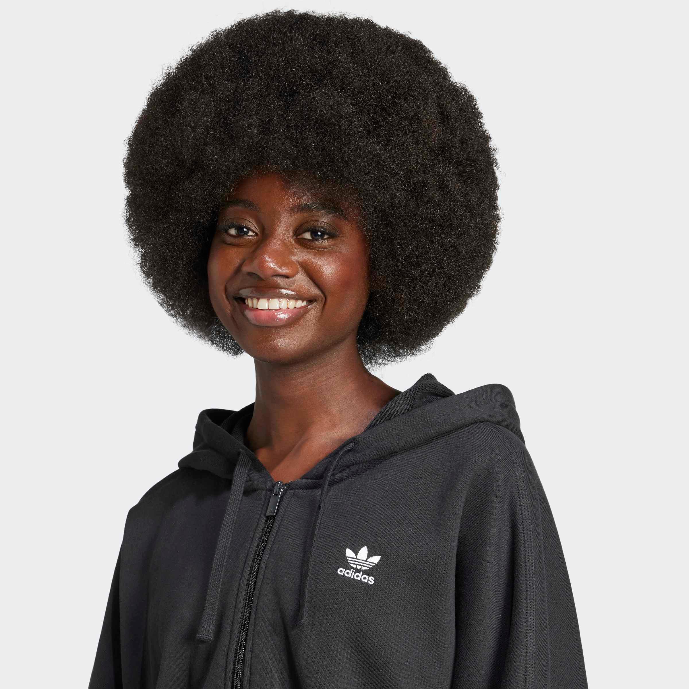 אישה מחייכת עם קפוצ'ון אדידס שחור לוגו, אופנה איכותית ב-CHOZEN