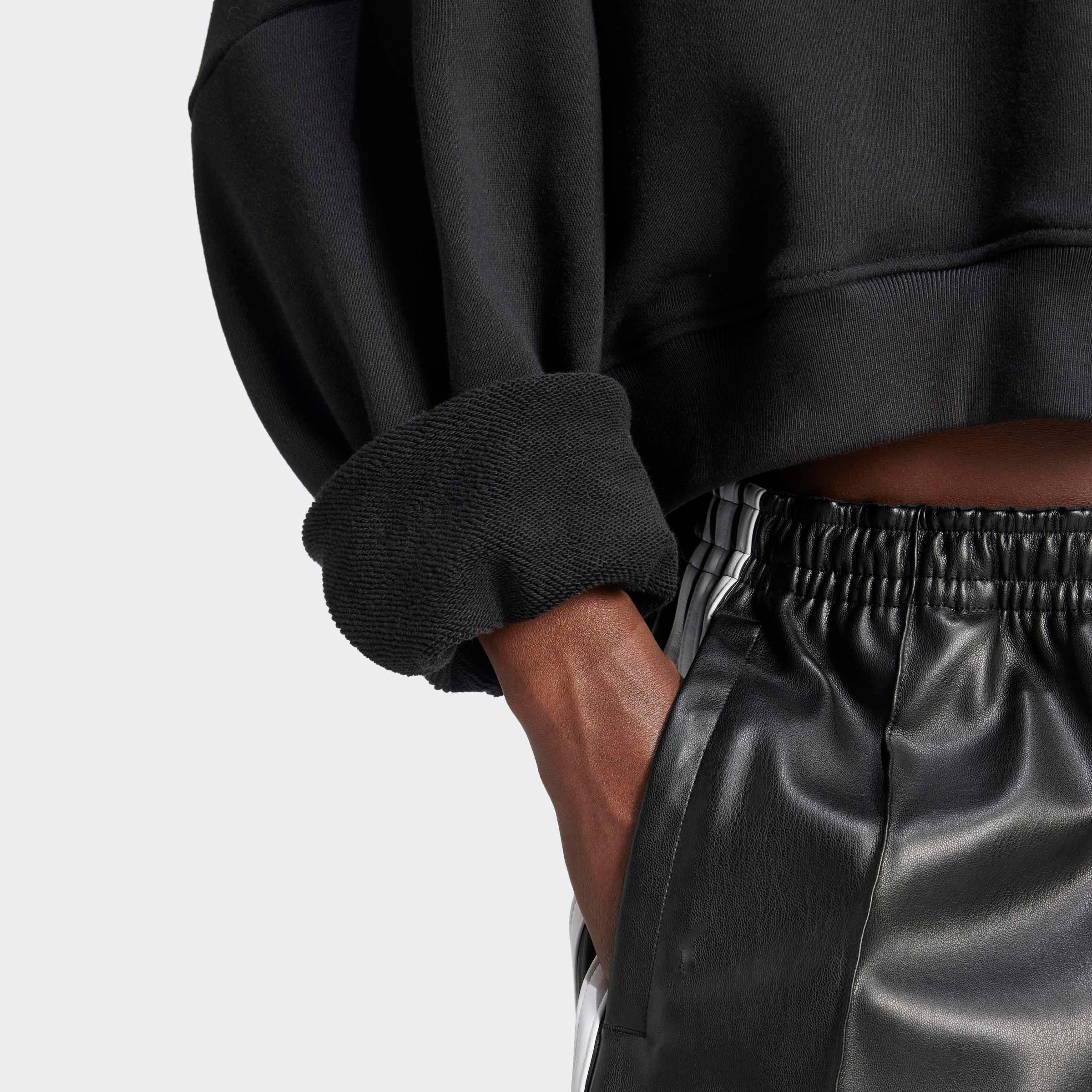 חולצת ספורט שחורה שרוול ארוך ומכנסי עור אופנתיים, צילום מקרוב לאתר CHOZEN