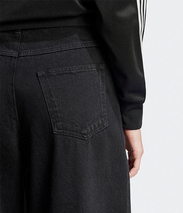 תקריב על ג'ינס שחור עם כיס אחורי ומקטורן ספורטיבי בחנות בגדי מותגים CHOZEN