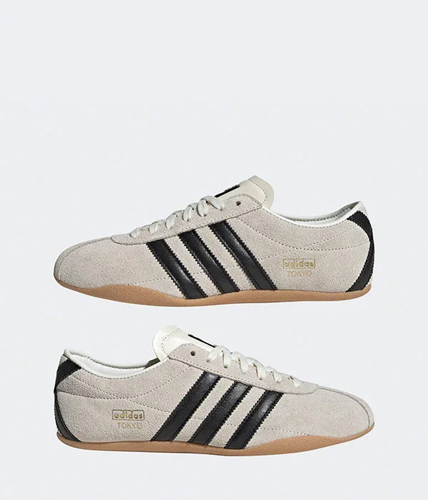 נעלי ספורט אפורות עם שלושה פסים שחורים, דגם adidas, על רקע לבן, מבית CHOZEN