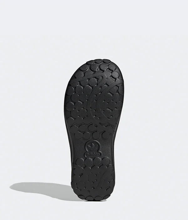 סוליית נעל אדידס שחורה עם דוגמת עיגולים, מוצגת על רקע אפור בהיר, CHOZEN