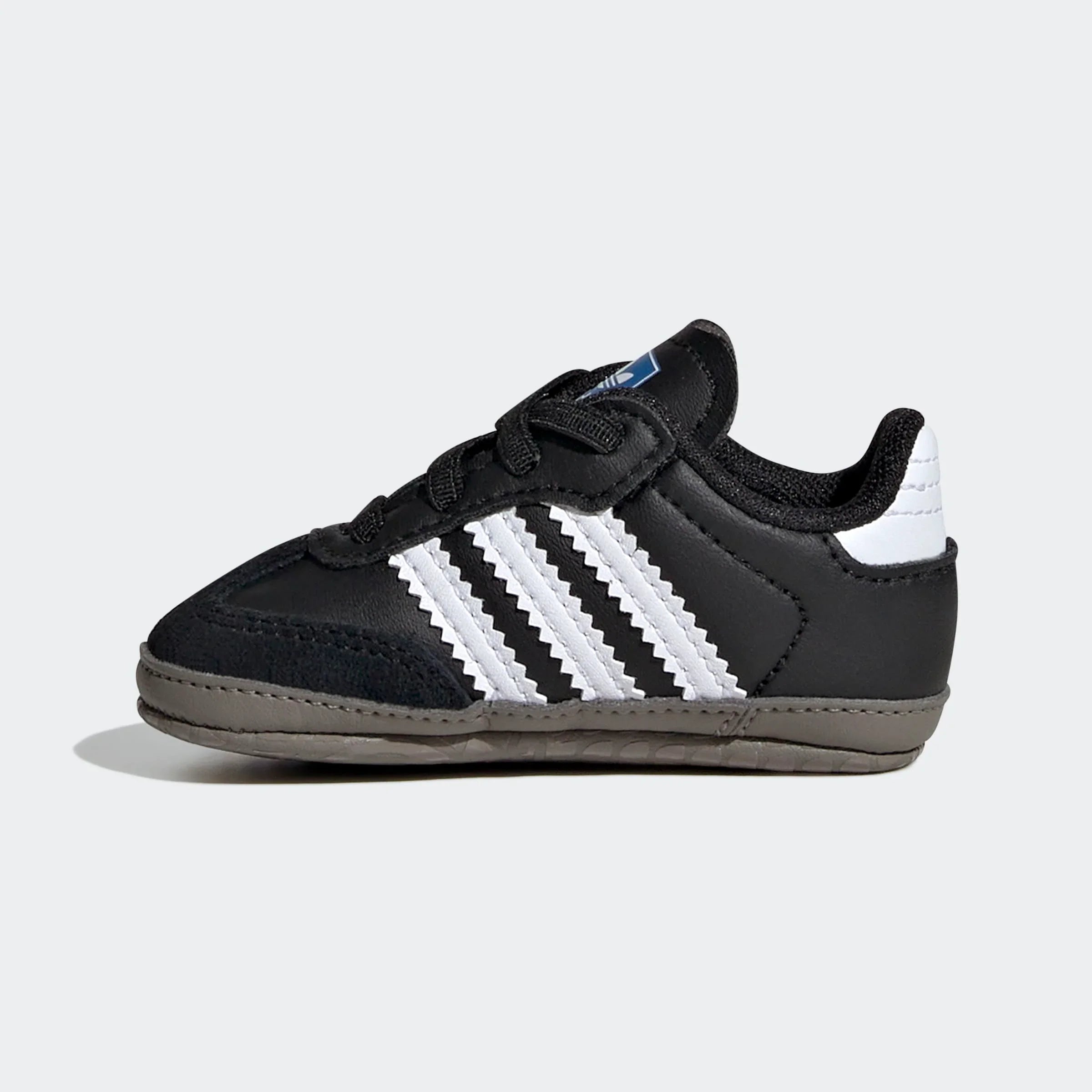 נעל ספורט תינוקות שחורה עם פסי צד לבנים וסוליה חומה, צילום צד