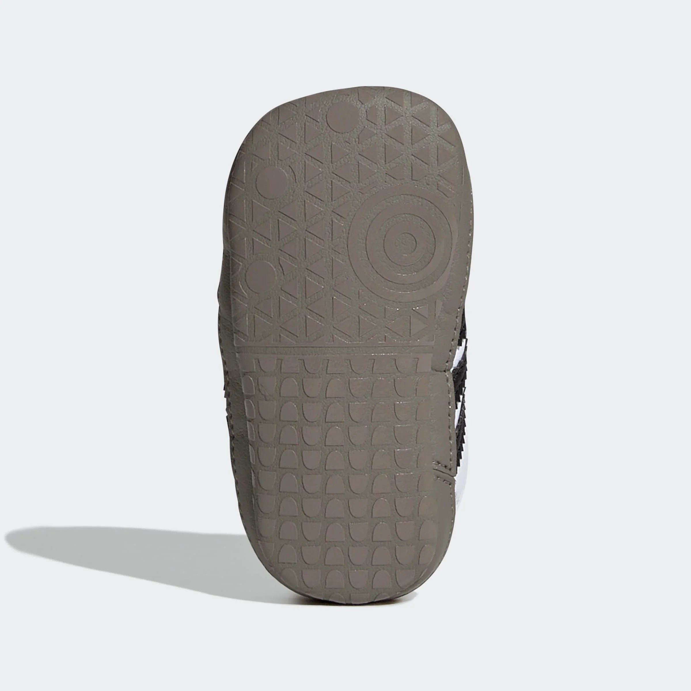 תחתית סוליית נעל ספורט אפורה עם דוגמת אחיזה ייחודית, רקע לבן נקי