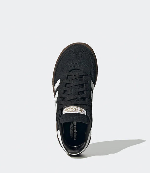 סניקרס adidas בעיצוב שחור עם פסים לבנים על רקע אפור, מצולם מלמעלה באתר CHOZEN