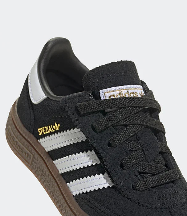 נעל ספורט שחורה adidas Spezial עם שלושה פסים לבנים, שרוכים, וסוליה חומה בחנות CHOZEN