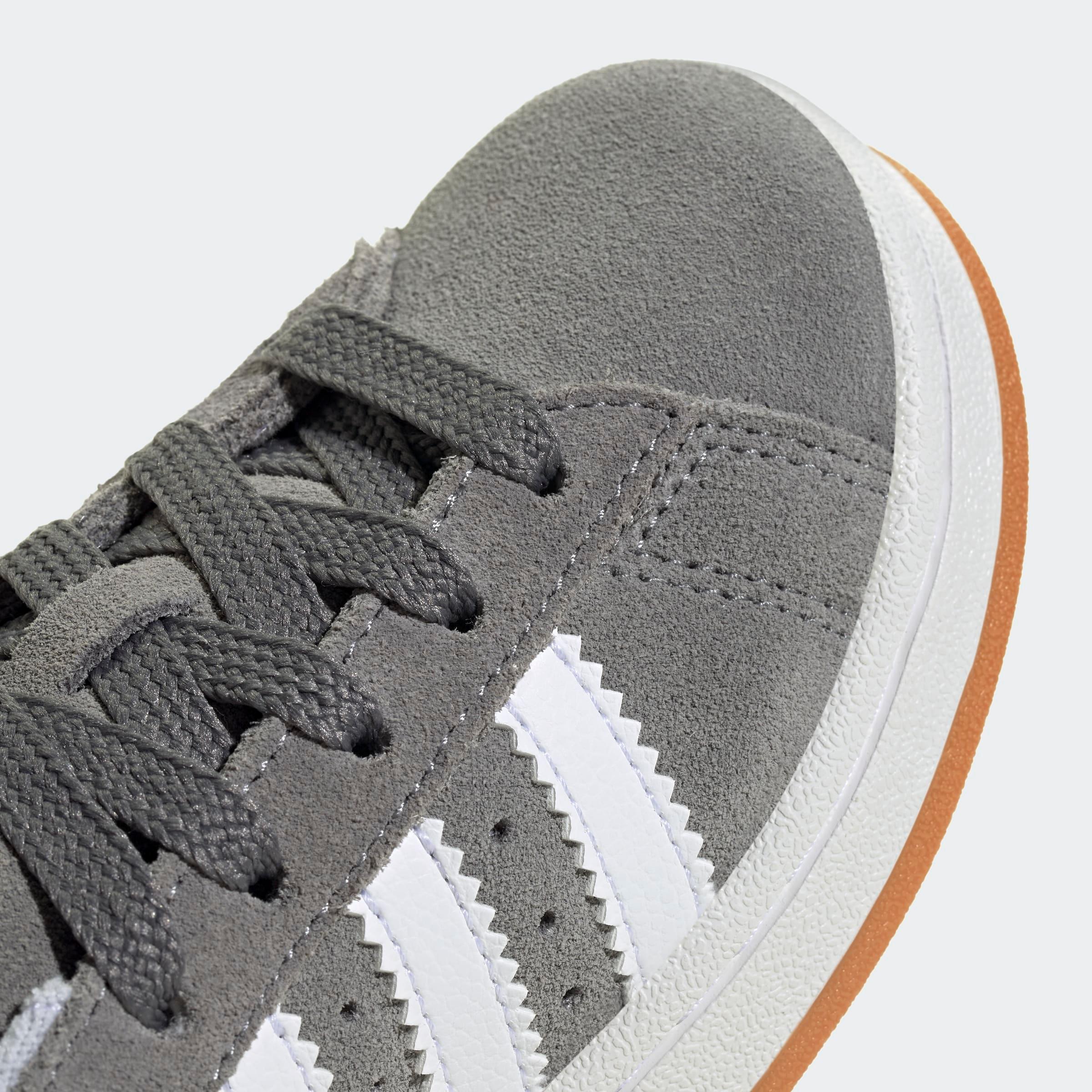 נעל ספורט אפורה עם שלושה פסים לבנים, שרוכים אפורים וסוליית גומי, ב-CHOZEN