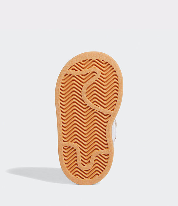 סוליית נעל ספורט בצבע כתום עם דפוס גומי, צילום מבט תחתון על רקע לבן