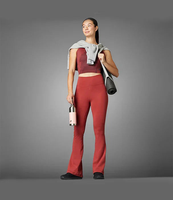 אישה בלבוש ספורט אדום עם מחצלת יוגה ובקבוק מותג אדידס, צילום אופנה CHOZEN