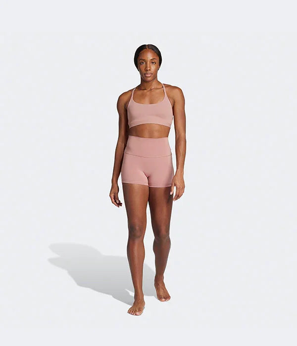 אישה לובשת סט פעילות גופנית ורוד קצר, ביגוד ספורט CHOZEN על רקע לבן