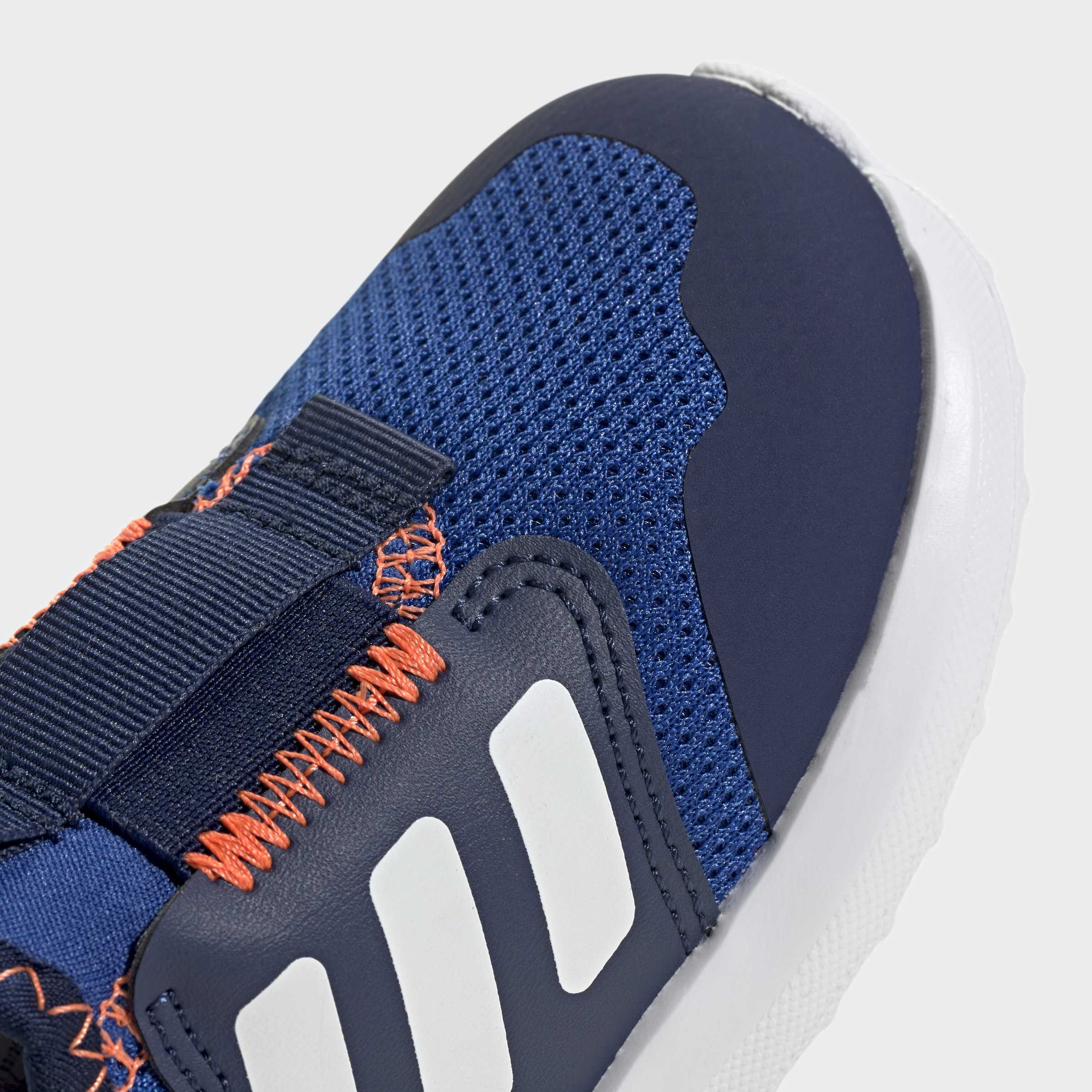 תקריב נעל ספורט כחולה עם רשת, תפרים כתומים וסוליה לבנה, פרטי עיצוב מודרני