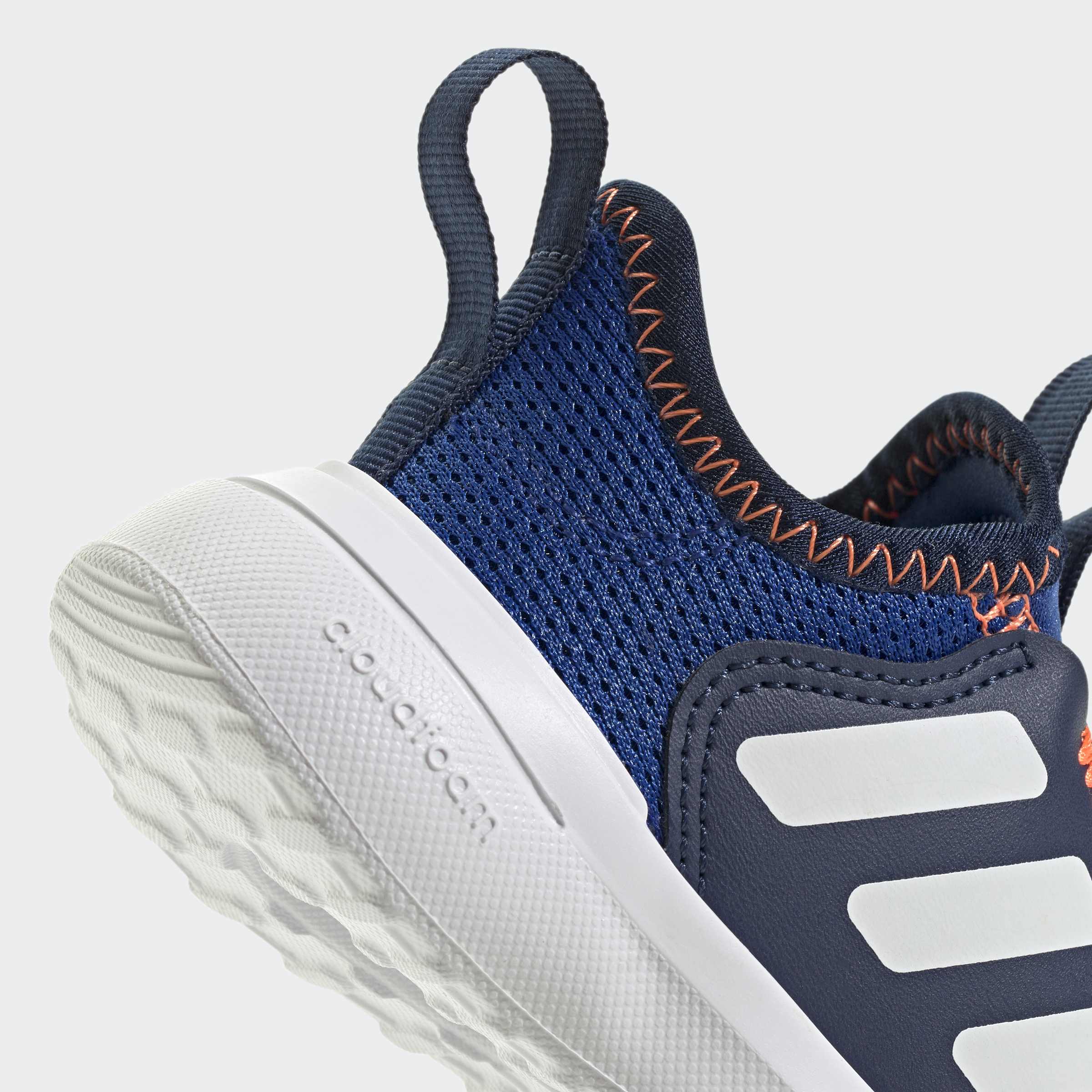 נעל ספורט כחולה עם סוליה לבנה, בד נושם ותפרים כתומים בולטים