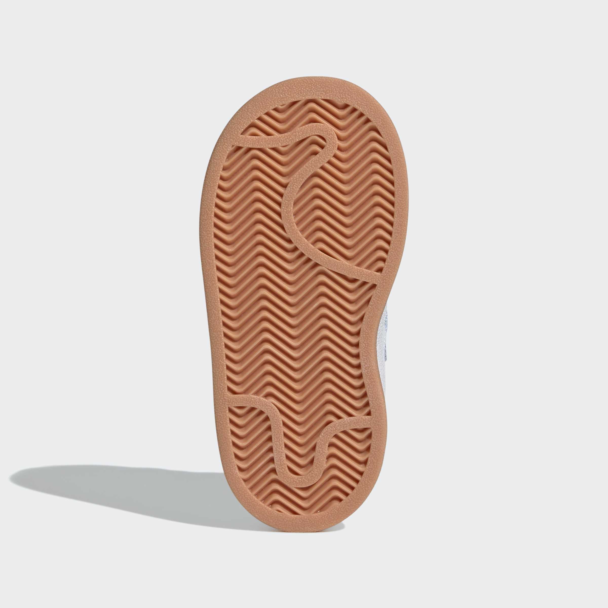 סוליית נעל ספורט בצבע כתום עם דוגמת זיגזג, צילום מלמטה על רקע לבן