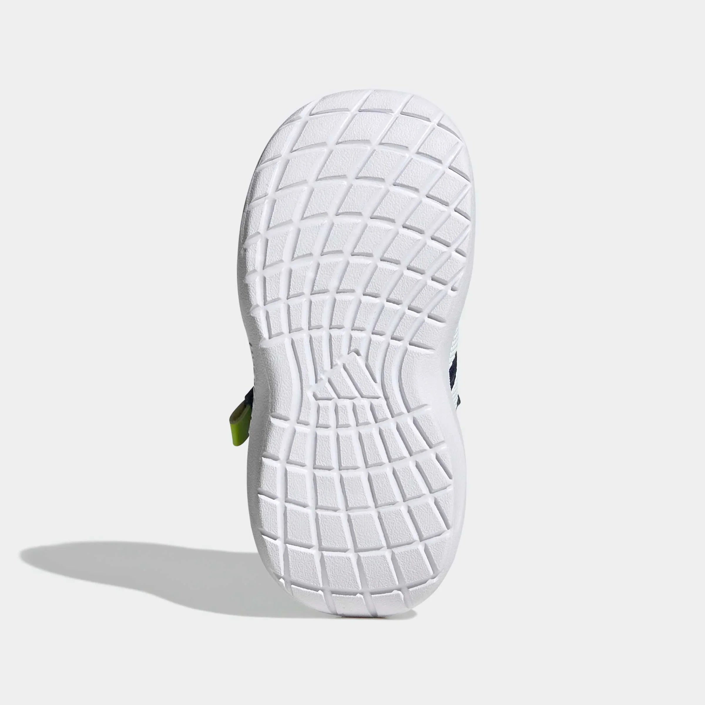 סוליית נעל ספורט בגוון לבן עם דוגמת רשת בולטת על רקע אפור