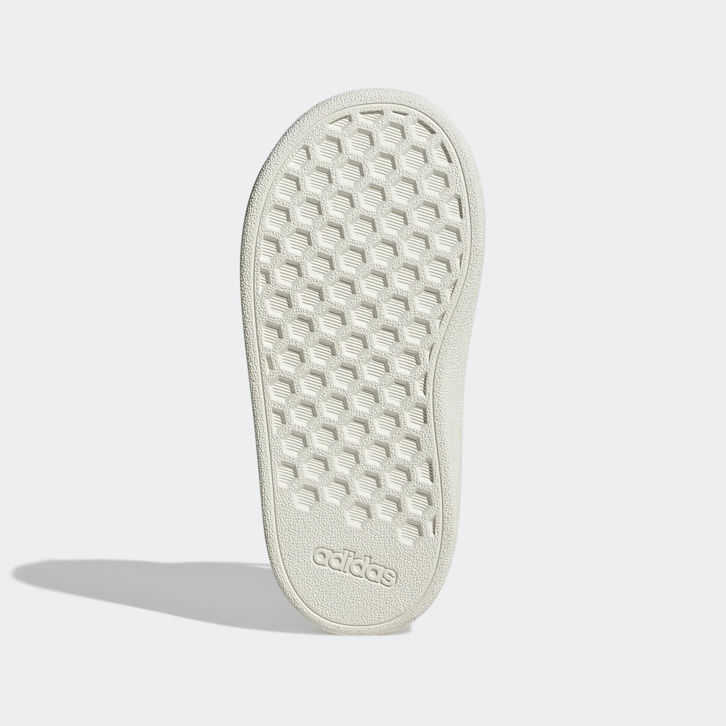 סוליה לבנה של נעל ספורט עם דוגמת חלת דבש ולוגו adidas בתחתית