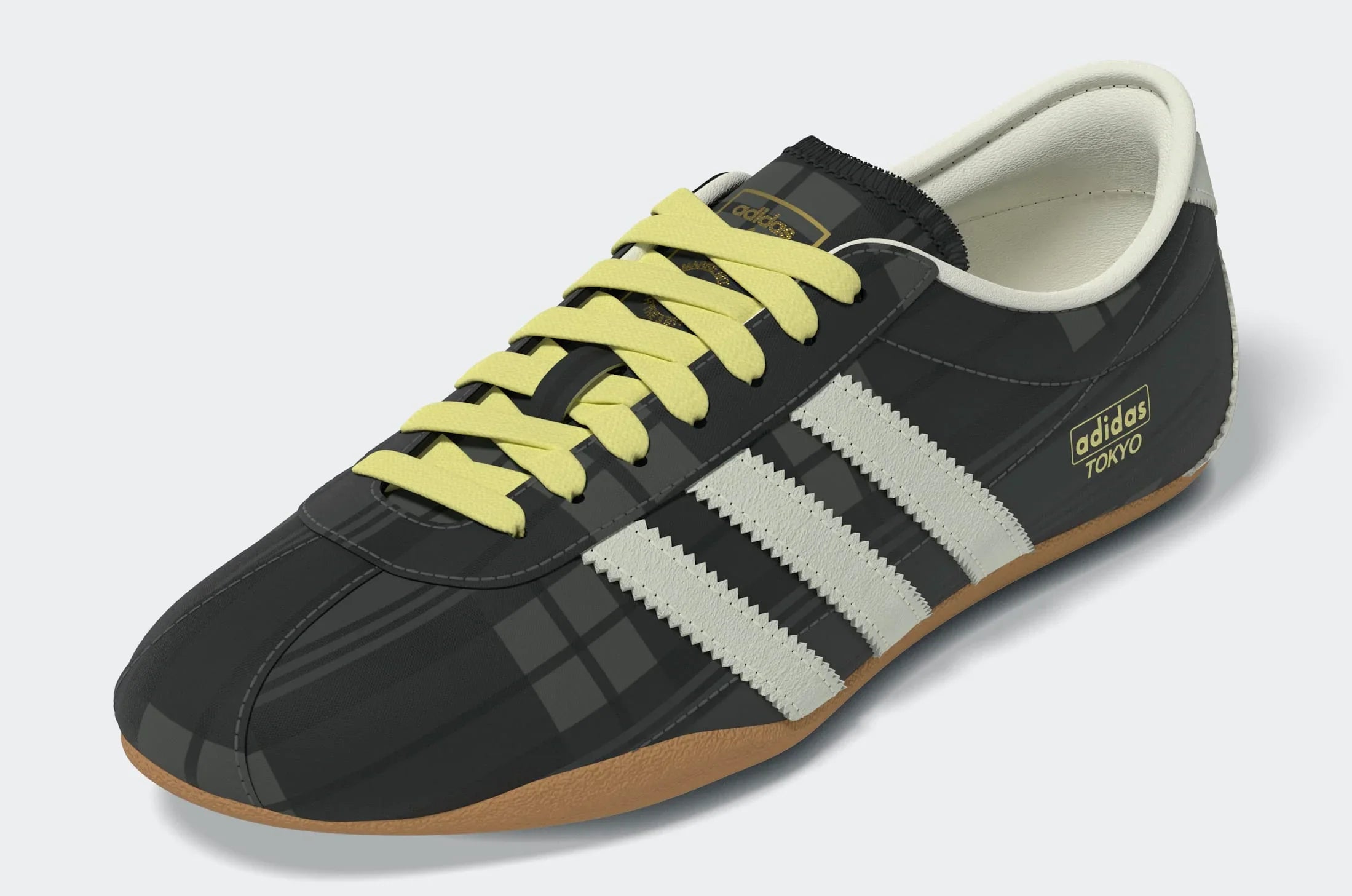 נעל אדידס טוקיו בצבע שחור עם שרוכים צהובים, שלושה פסים לבנים וסוליה חומה