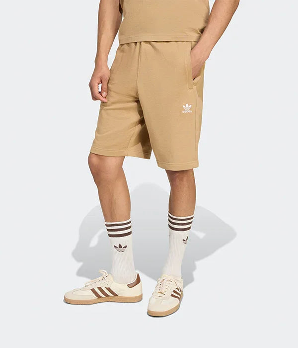 דגם גבר לובש שורט בז׳ אדידס, גרביים ונעליים ממותגות, בסטייל ספורטיבי CHOZEN