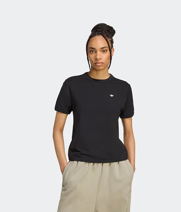 אישה לובשת חולצת טי שחורה של אדידס ומכנסי טרנינג בז', צילום אופנה CHOZEN