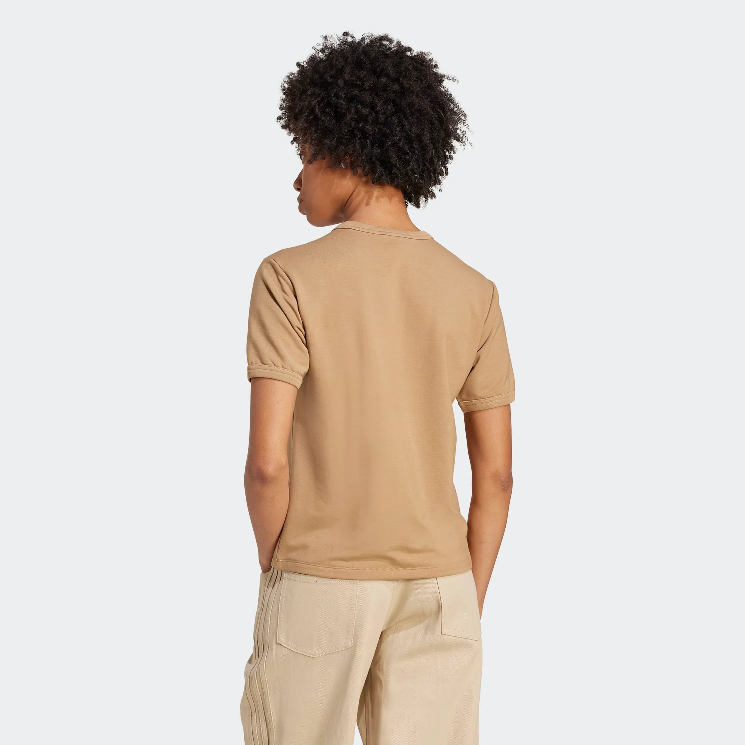 אישה עם חולצת טי שרט בצבע בז' ומכנסיים בהירים, צילום גב לאופנה באתר CHOZEN