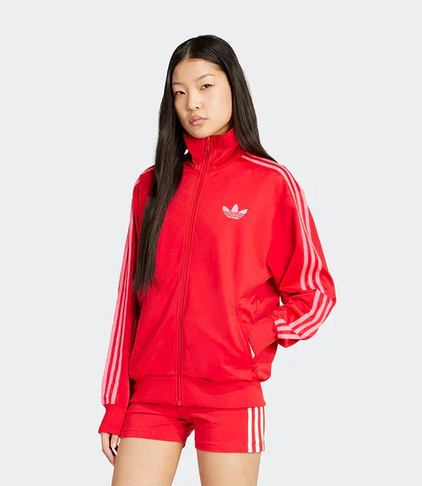 דגם לובשת סט ספורט אדום עם שלושה פסים ומותג אדידס, רקע אפור - CHOZEN