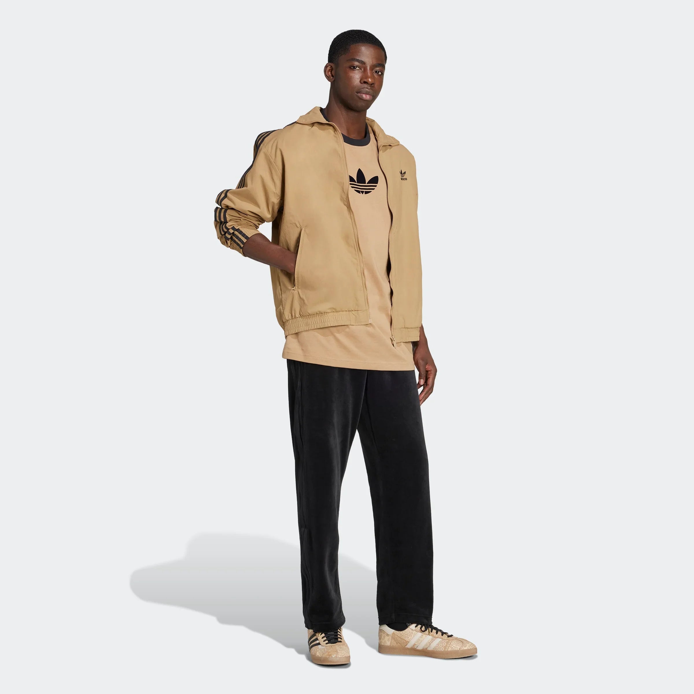 דוגמן לובש בגדי אדידס בצבע בז' ושחור על רקע לבן, אופנה לגבר מבית CHOZEN