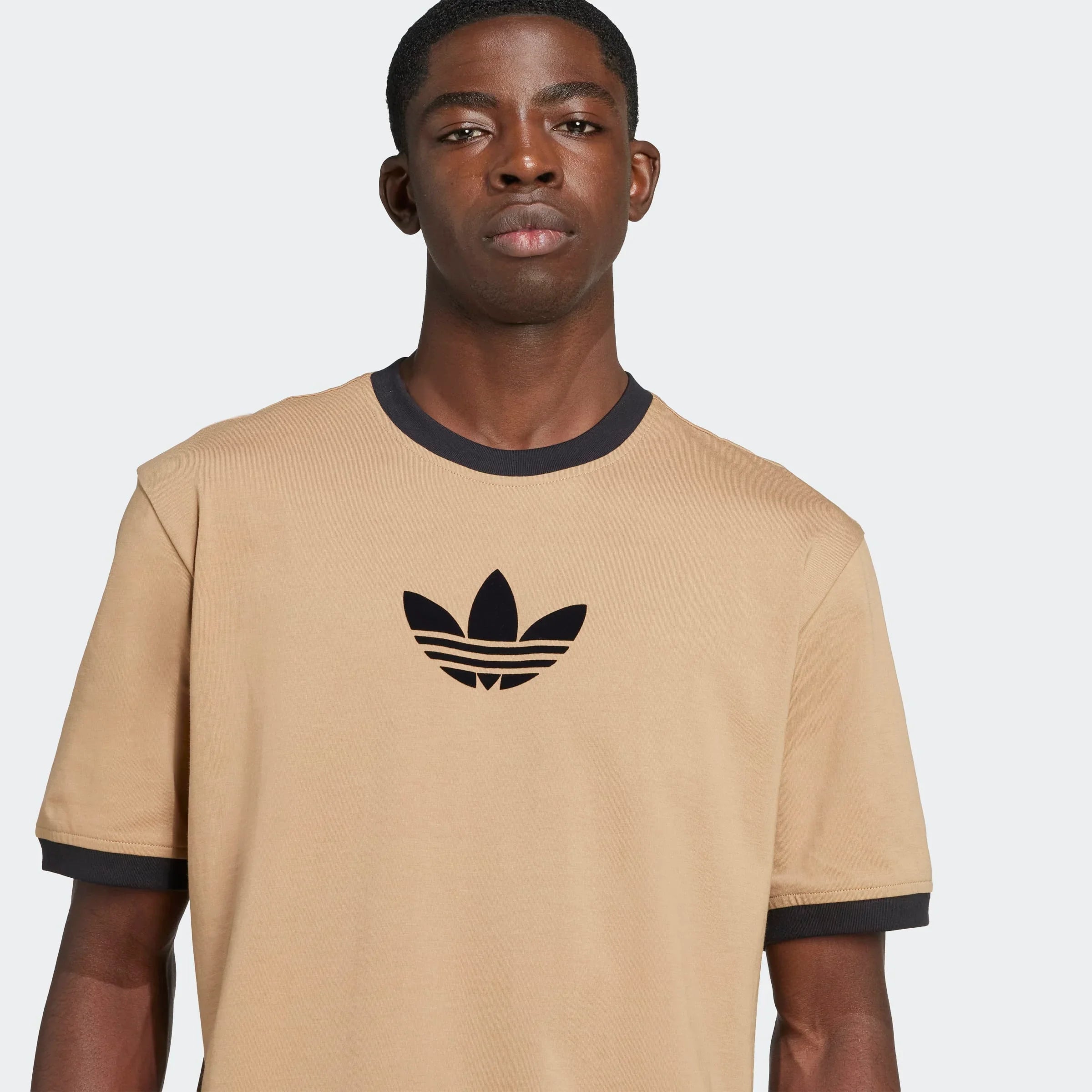 גבר לובש טי שירט בז׳ לוגו אדידס, אופנת רחוב, מותגים בינלאומיים CHOZEN