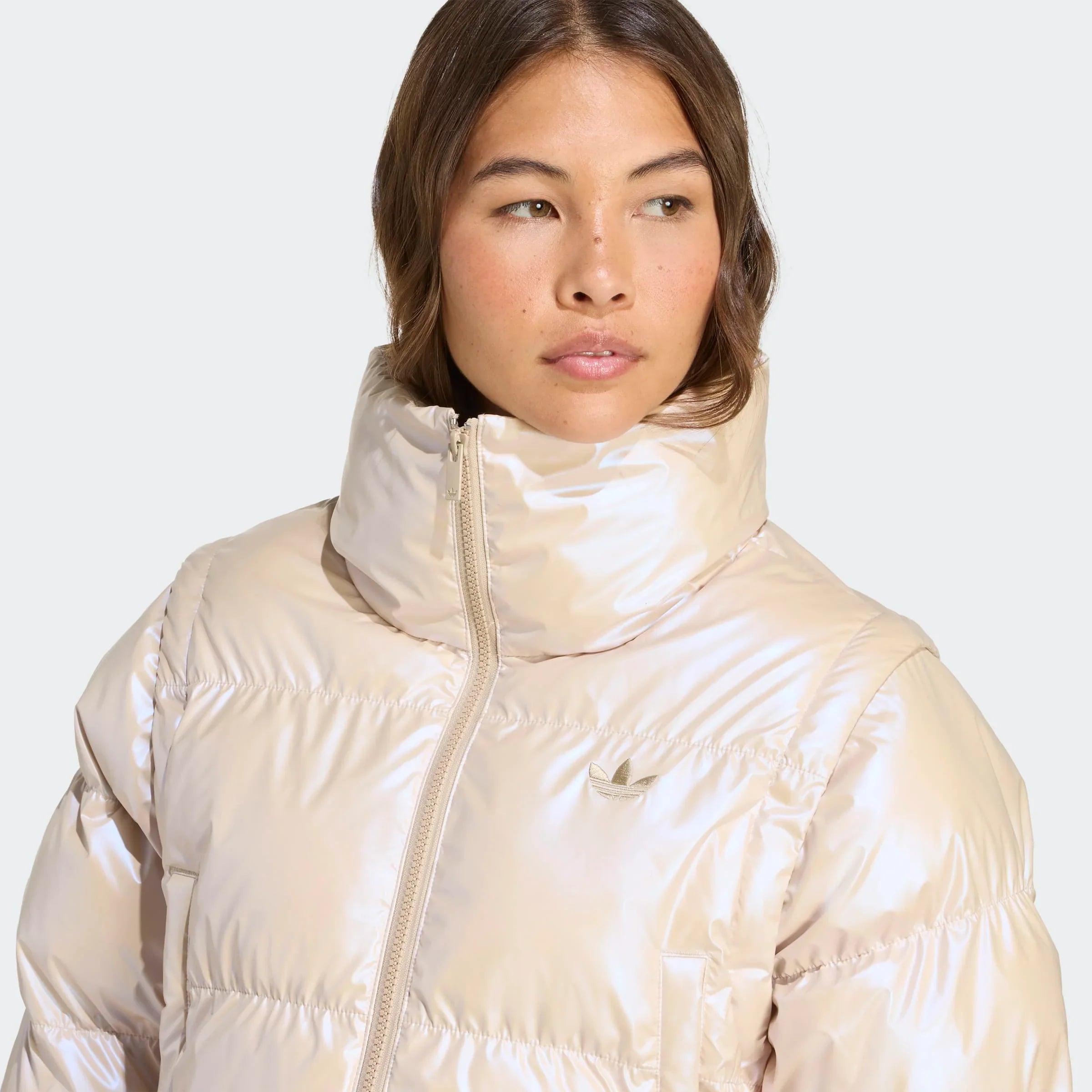 אישה לובשת מעיל פוך מנצנץ בצבע בז' עם לוגו adidas, צילום מקרוב, CHOZEN מותגים מובילים
