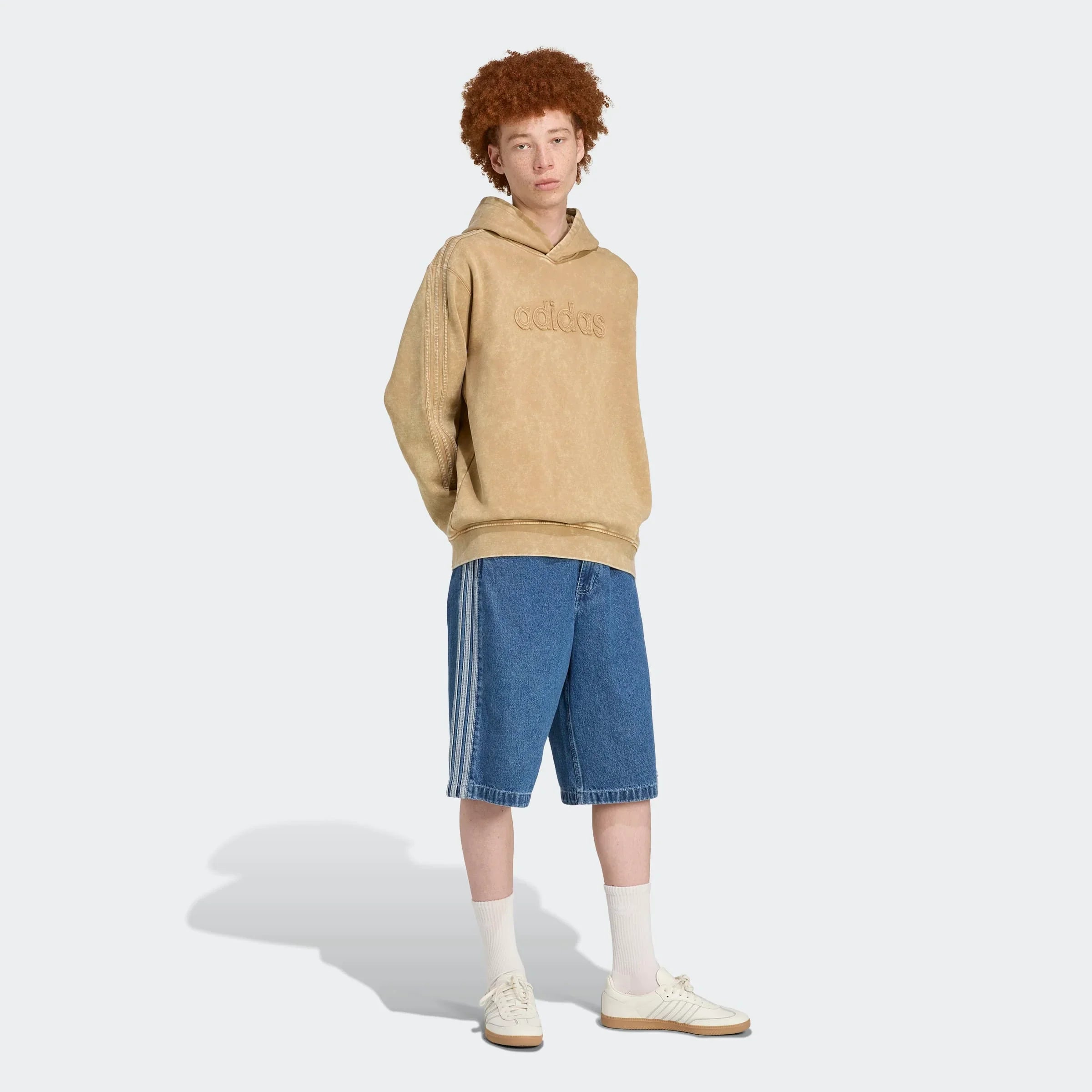 דוגמן לובש סווטשירט אדידס בז' עם קפוצ'ון ומכנס ג'ינס קצר, CHOZEN מותגים מובילים