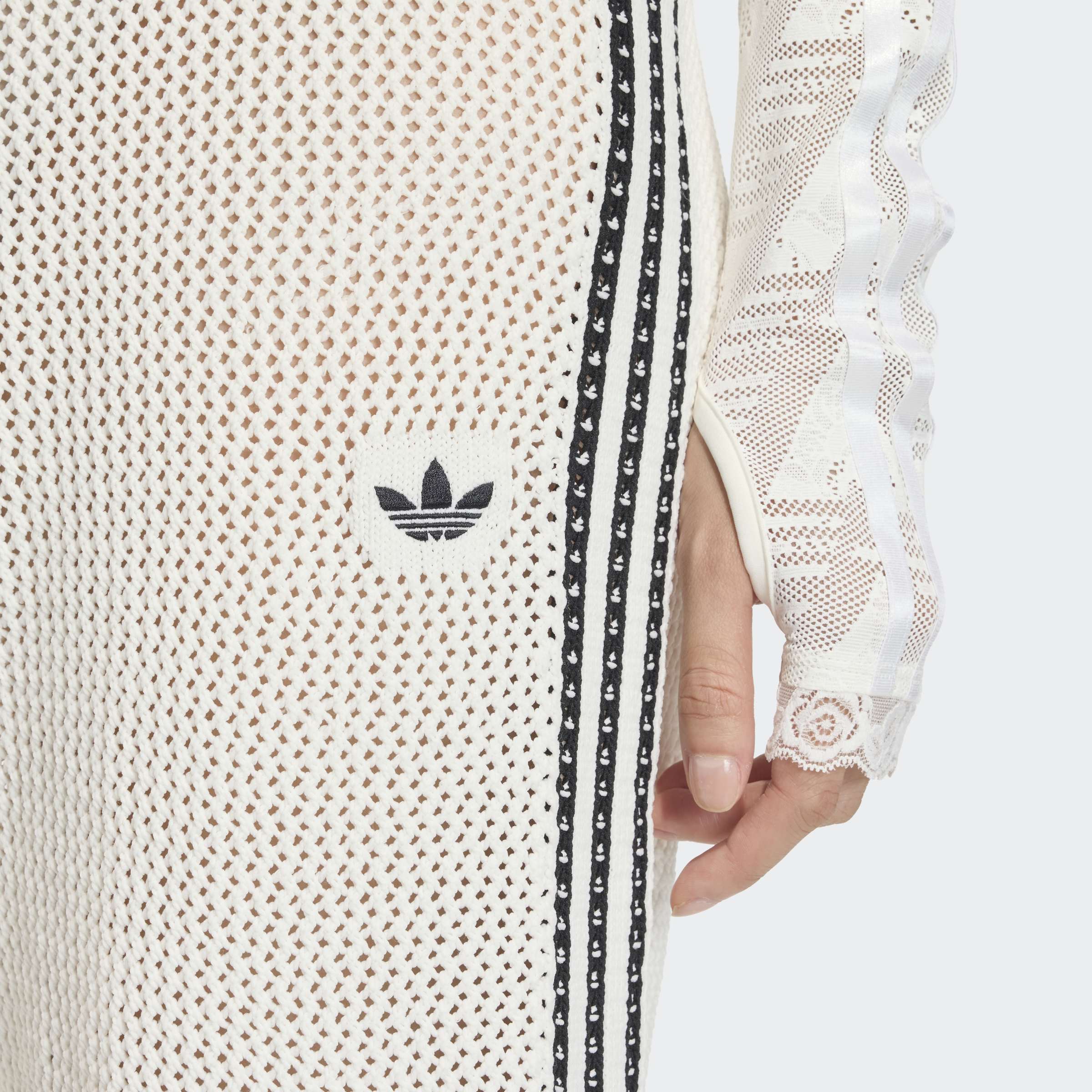 תקריב שמלה רשת לבנה עם פסים שחורים ולוגו על הבד, דגם אופנה טרנדי