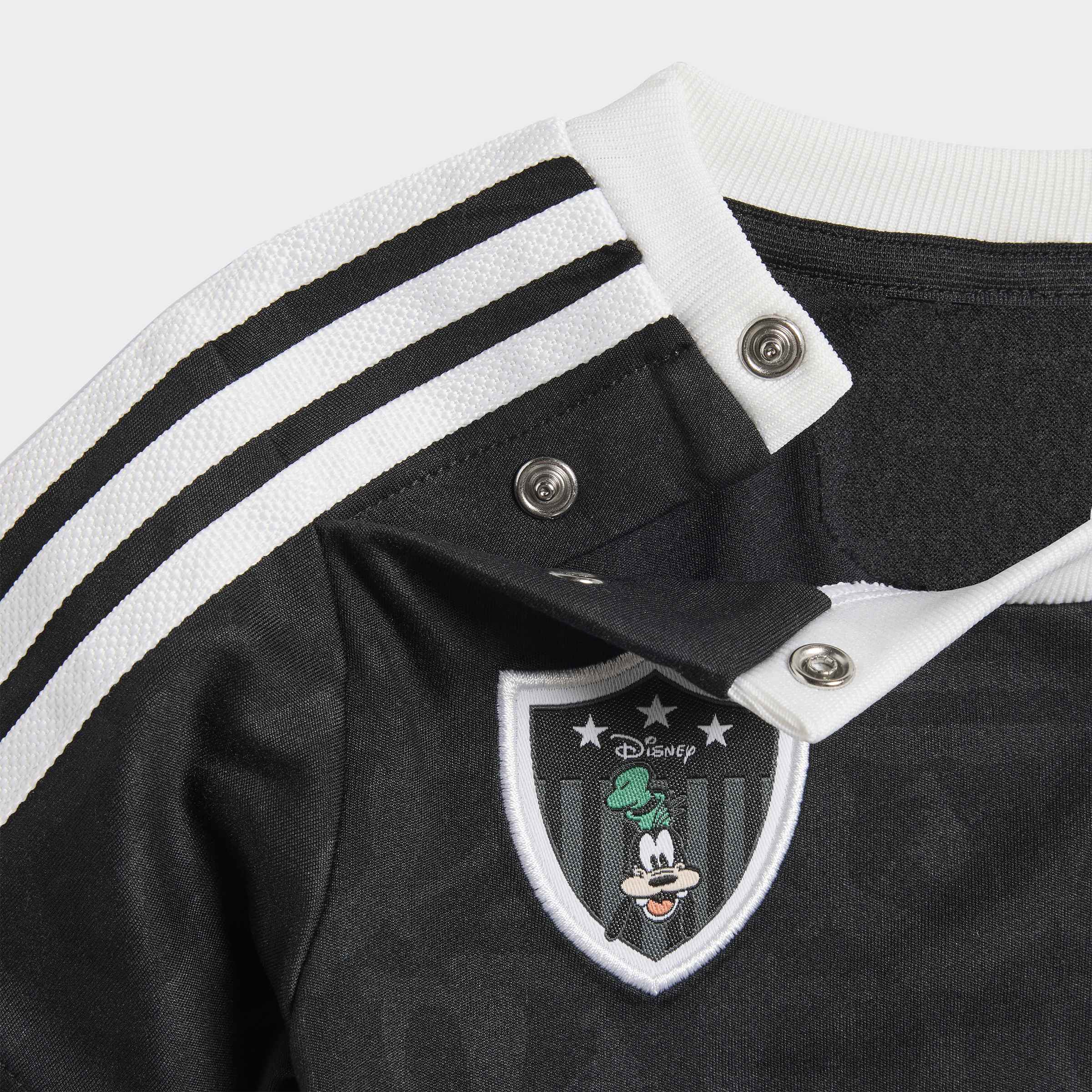 חולצה שחורה עם פסים לבנים, כפתורי תיקתוק וסמל דמויות דיסני רקום