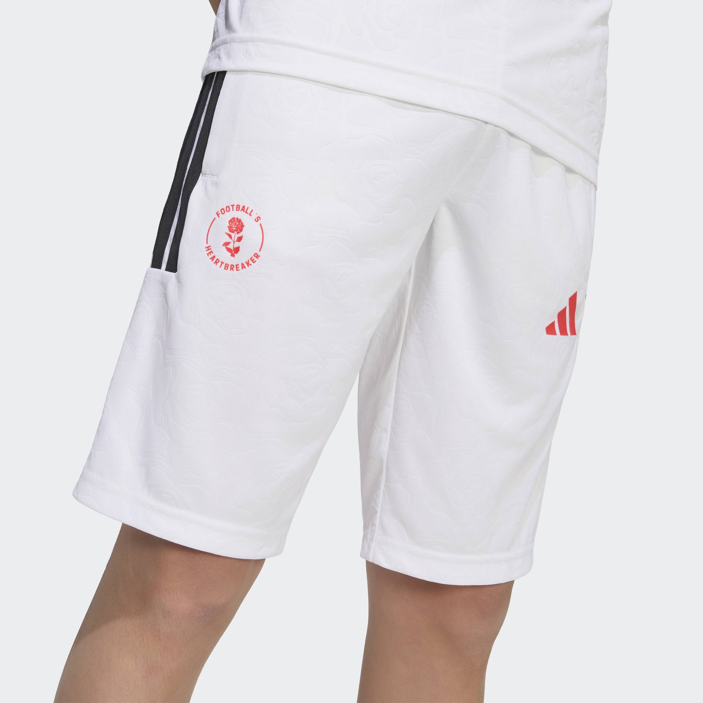 מכנסי ספורט קצרים לבנים עם פס שחור, רקע לוגו אדום ועיטור ורדים, מצולמים על דוגמן