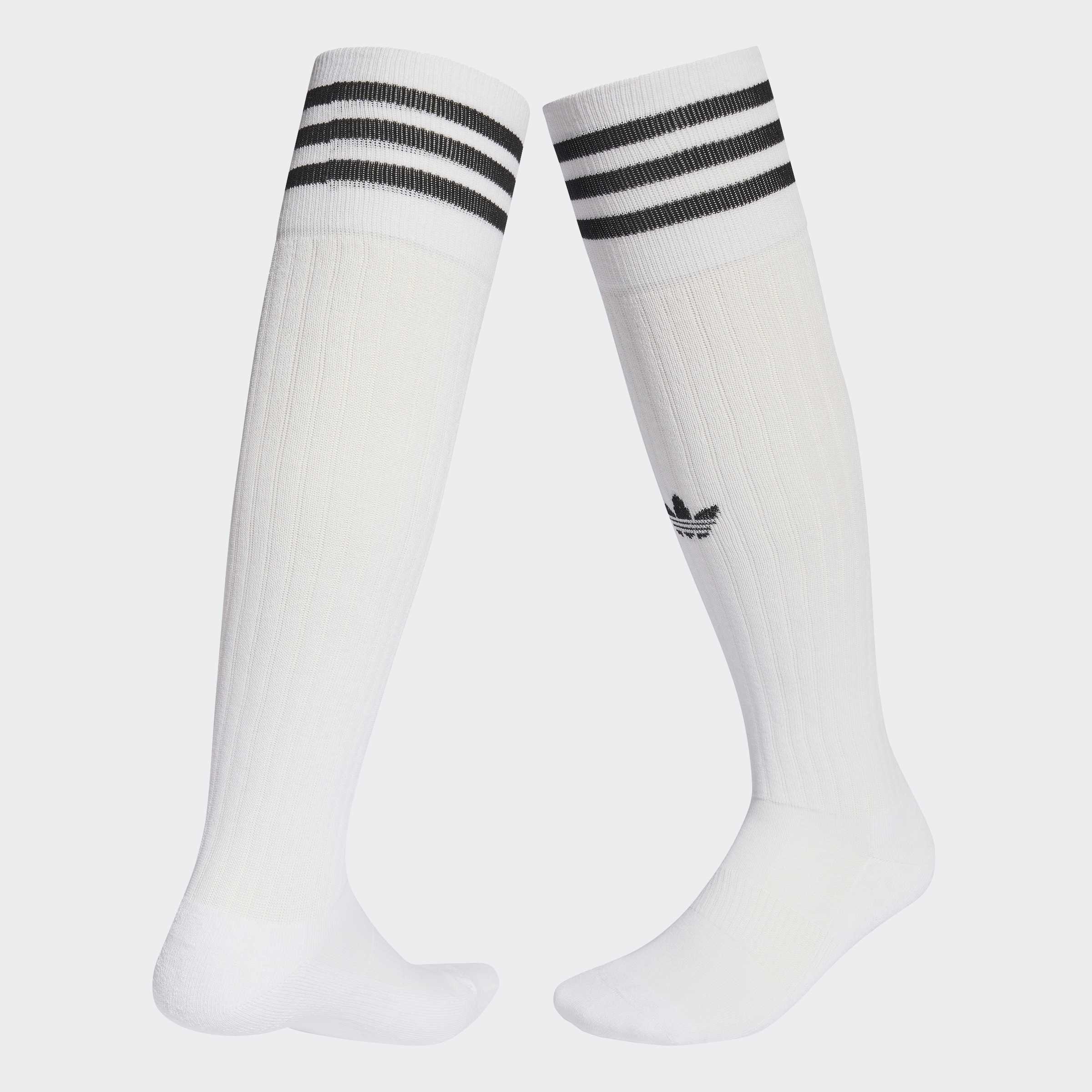 גרביים גבוהים לבנים עם שלושה פסים שחורים למעלה ולוגו קטן שחור בצד