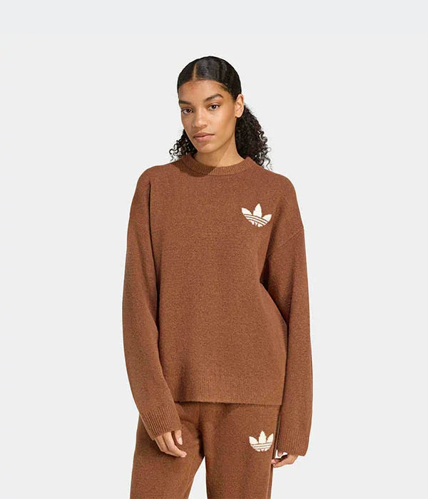 דוגמנית לובשת סט סוודר ומכנסיים חום עם לוגו אדידס, רקע בהיר, קמפיין CHOZEN