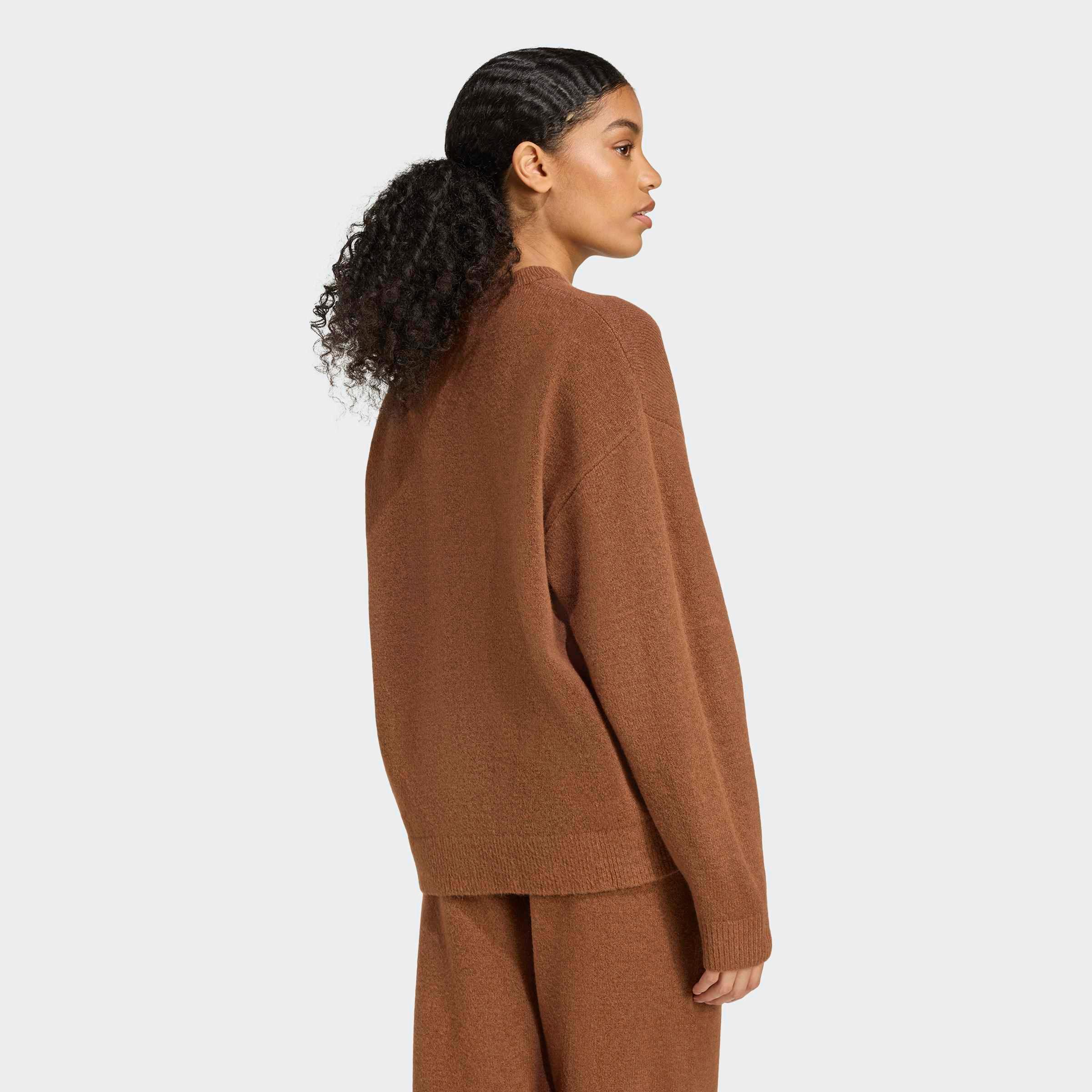 דוגמנית בגב סווטשירט ומכנסיים חומים, אופנת נשים CHOZEN, רקע לבן