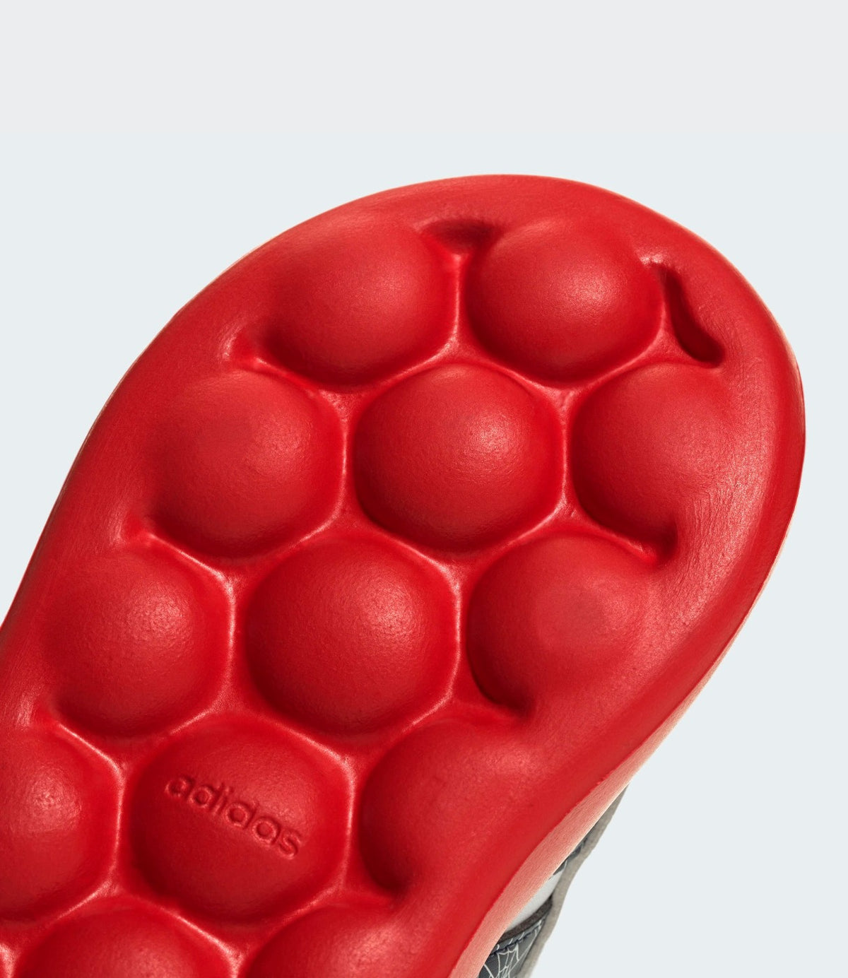 תקריב על סוליית הגומי האדומה עם לוגו אדידס - CHOZEN