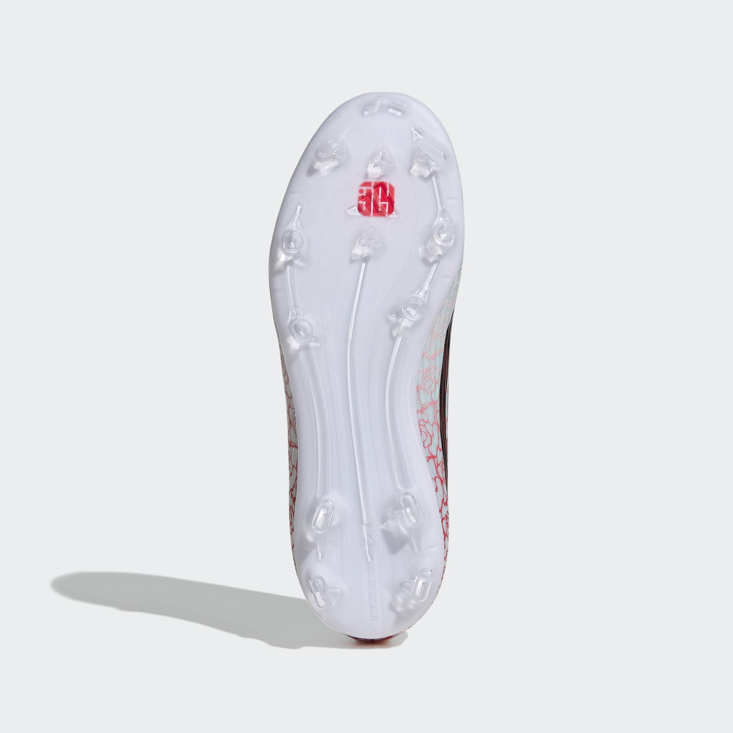 סוליית נעלי כדורגל עם דוקרנים, מבט תחתון, צבע לבן עם פרטים אדומים