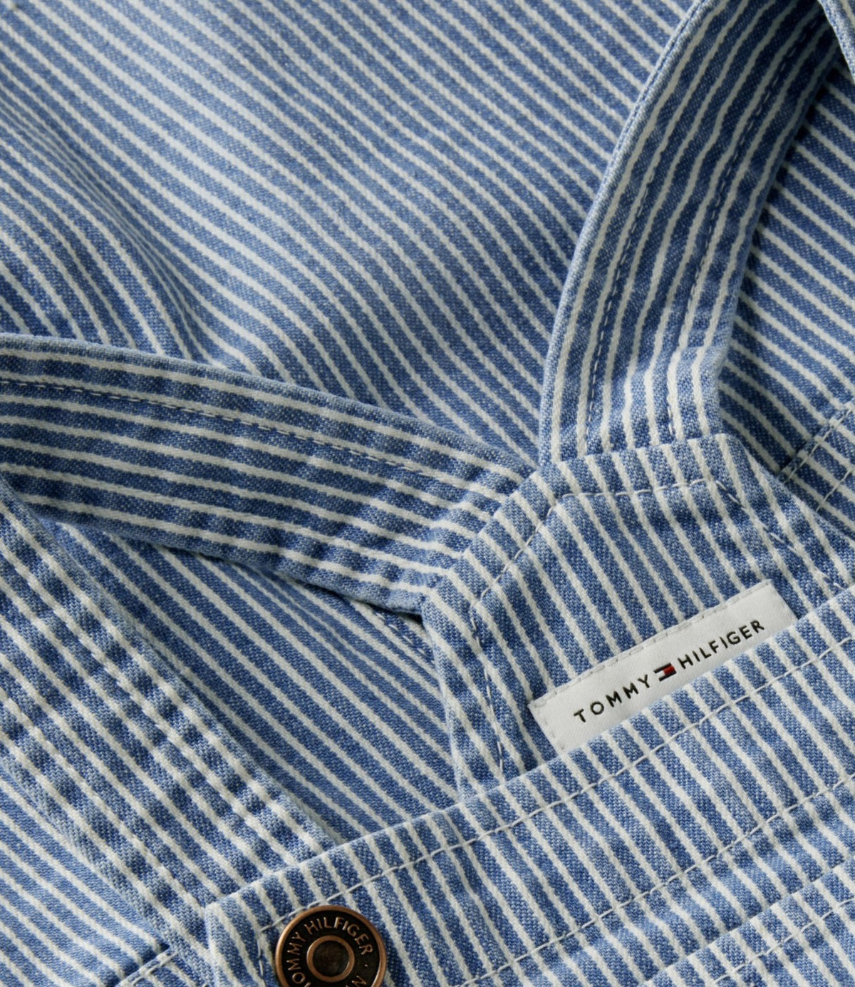 תקריב על תווית הלוגו והכפתור בפינת האוברול הכחול - CHOZEN