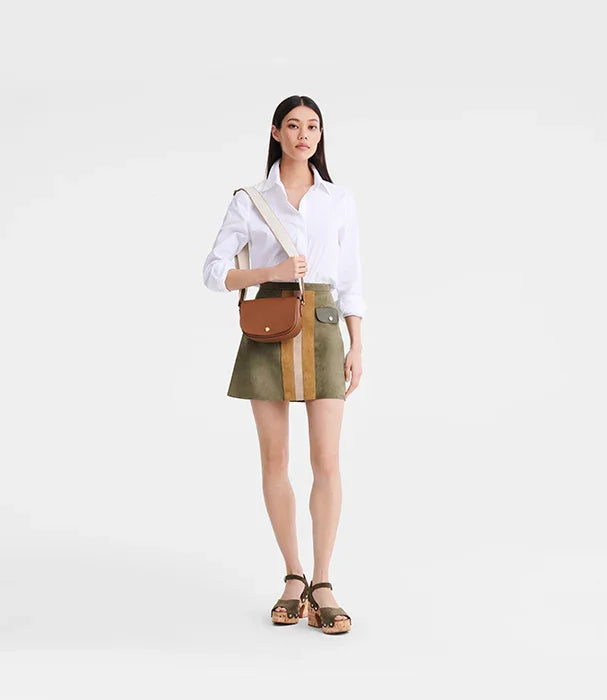 אישה עם חולצה לבנה, חצאית ירוקה, תיק צד חום ונעלי עקב, צילום אופנה ל-CHOZEN