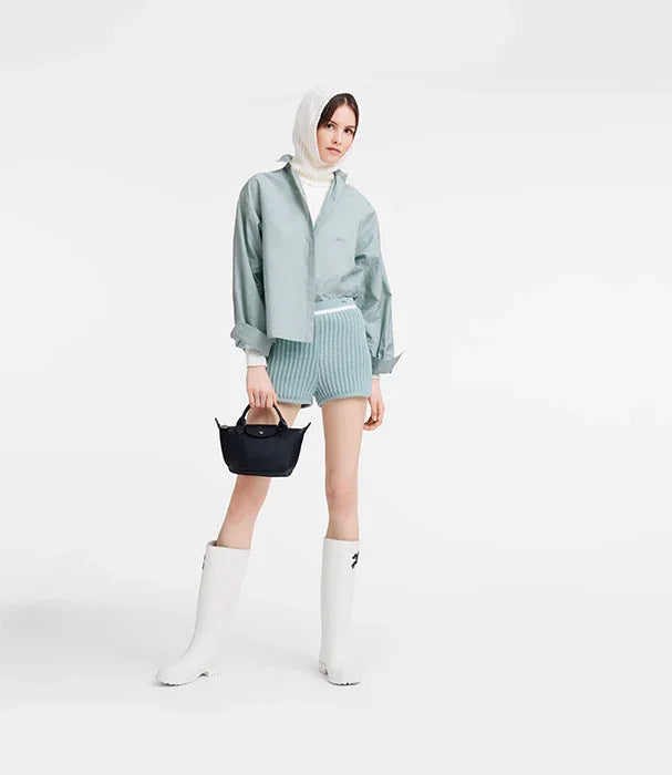 אופנת נשים בסגנון מודרני, דגם CHOZEN, מעיל ירוק, מגפיים לבנים ותיק שחור על רקע לבן