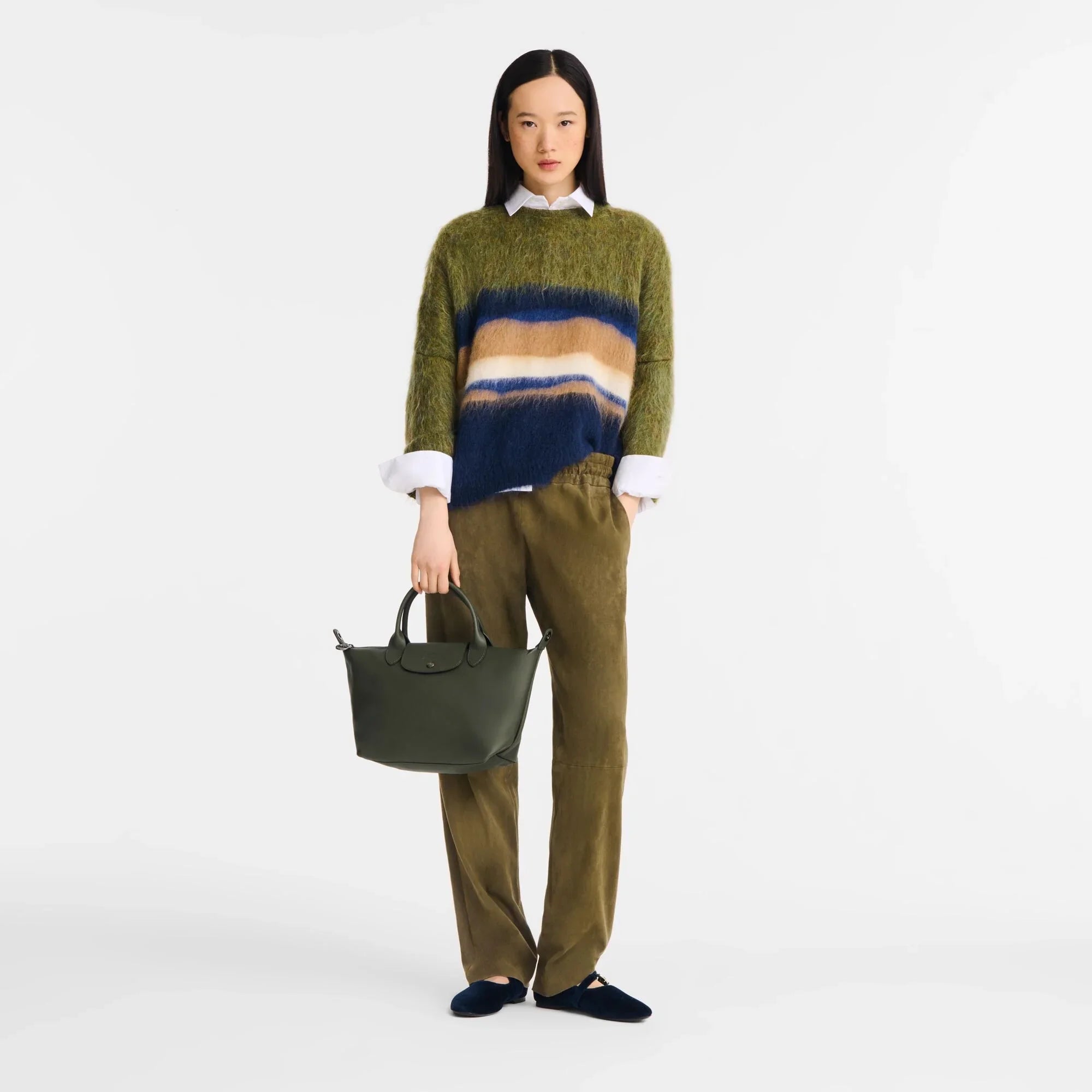 אישה עם סוודר צמר ירוק-כחול, מכנסיים ירוקים ותיק מעוצב, אופנה יוקרתית CHOZEN