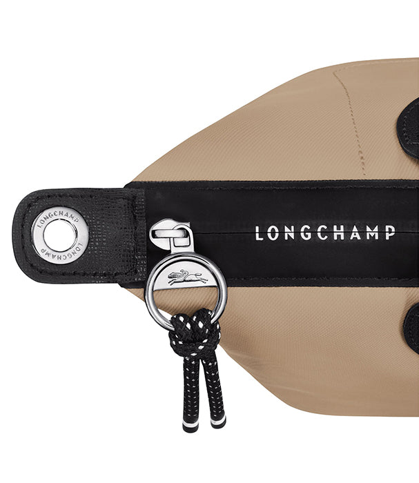 תקריב תיק LONGCHAMP בצבע בז' עם רצועה שחורה ולוגו, קולקציית מותגים ב-CHOZEN
