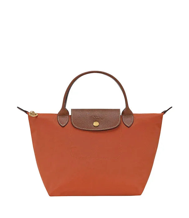 תיק יד כתום עם ידיות ועיטורים חומים, מוצר אופנה יוקרתי ב-CHOZEN קבוצת אלפא