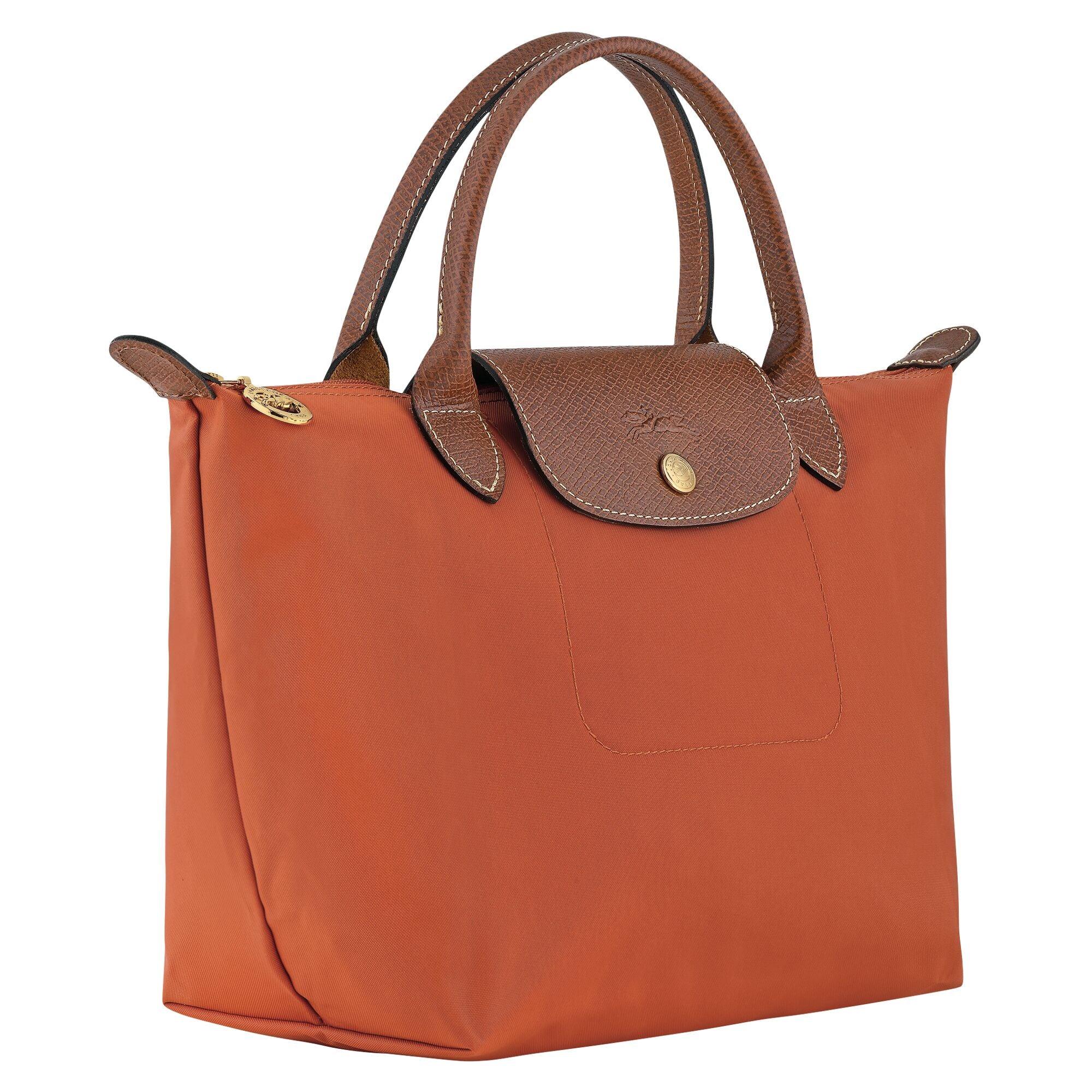 תיק יד אופנתי בצבע כתום עם ידיות ועיטורי עור חום, מוצר ממותג באתר CHOZEN