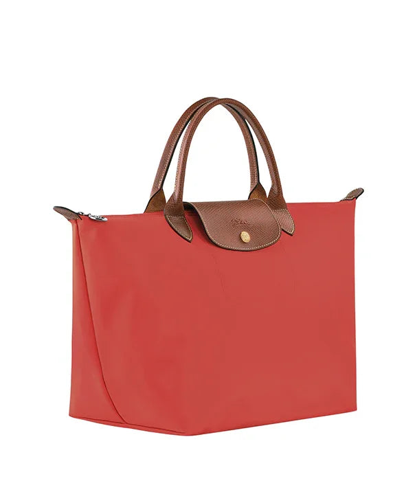 תיק יד אדום עם ידיות ועיטורים חומים, מבית מותג אופנה יוקרתי ב-CHOZEN