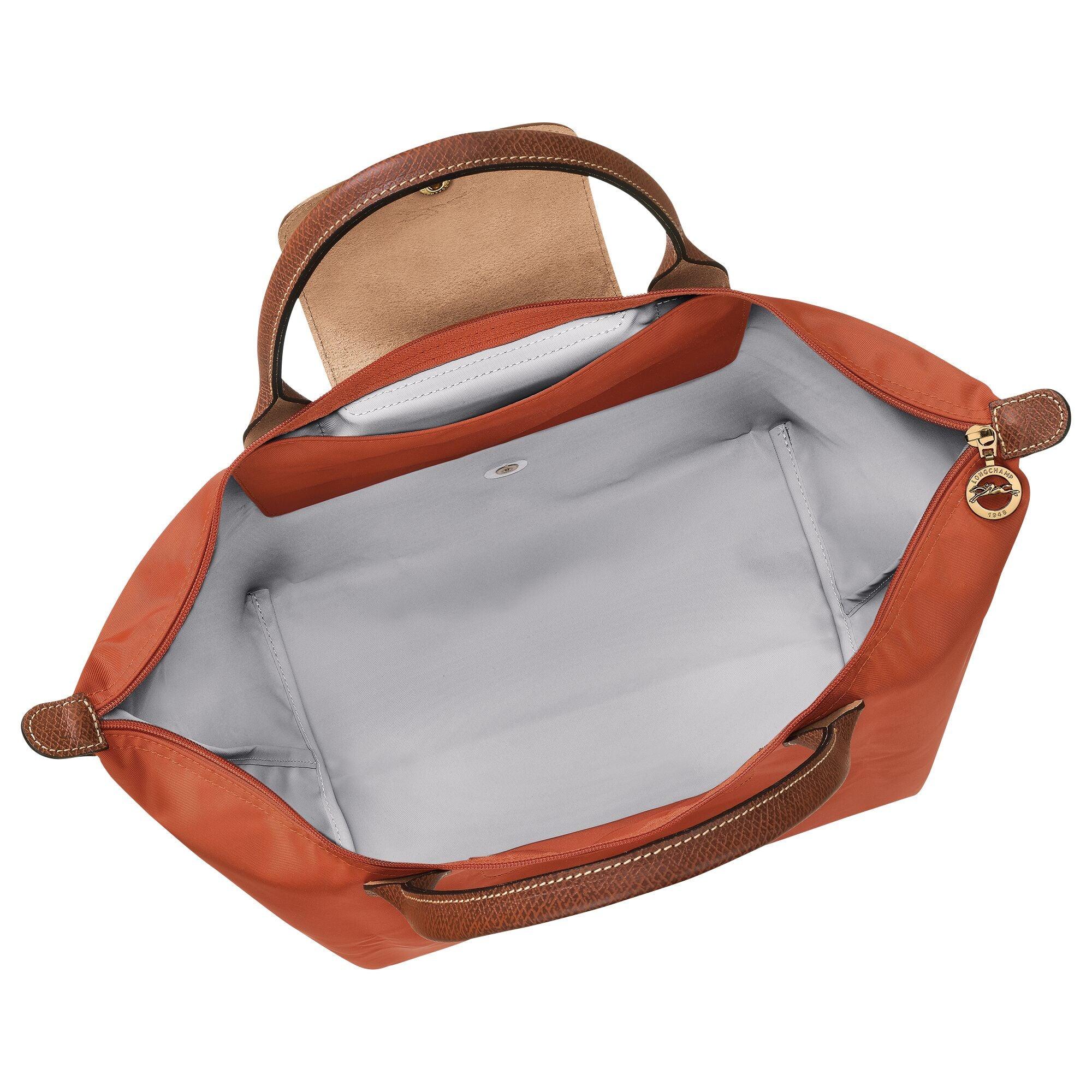 תיק יד כתום עם רצועות חומות, רוכסן זהב, מבית קבוצת אלפא, צילום מלמעלה