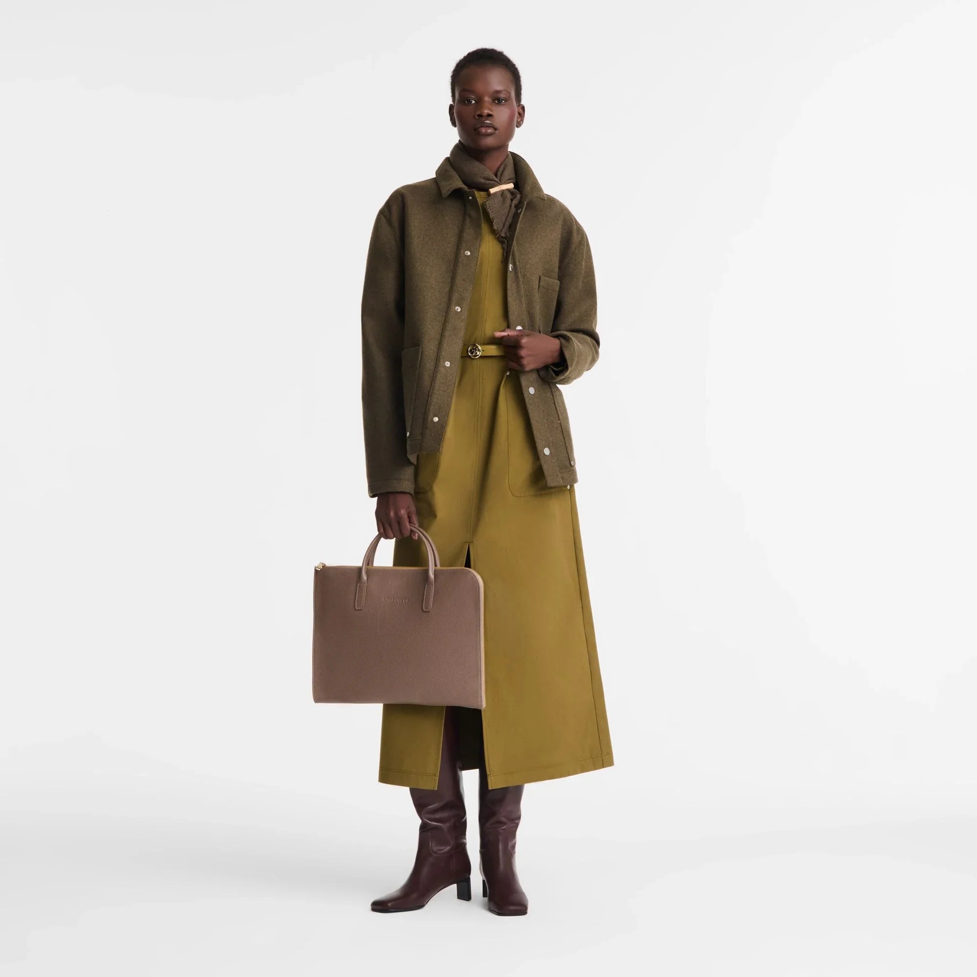 אופנת נשים יוקרתית, דוגמנית בלבוש חורפי בגווני זית וירוק מחזיקה תיק אלגנטי מ-CHOZEN